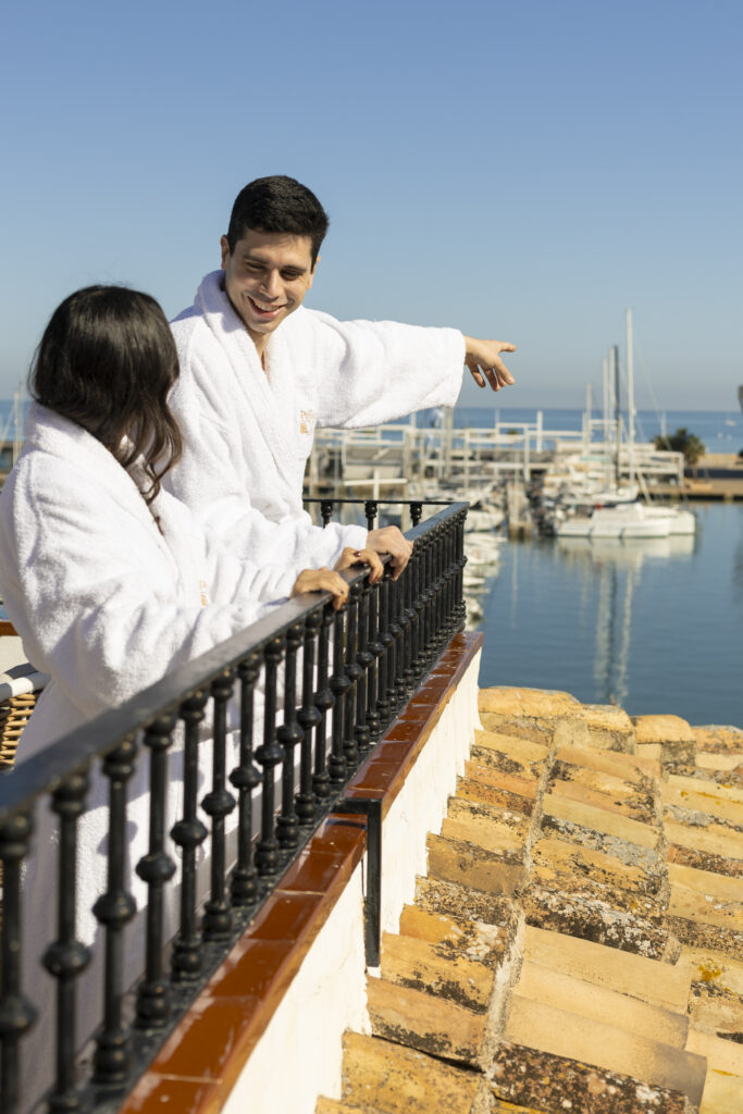 Una pareja disfrutando de las buenas vistas en la terraza de su habitación en el hotel