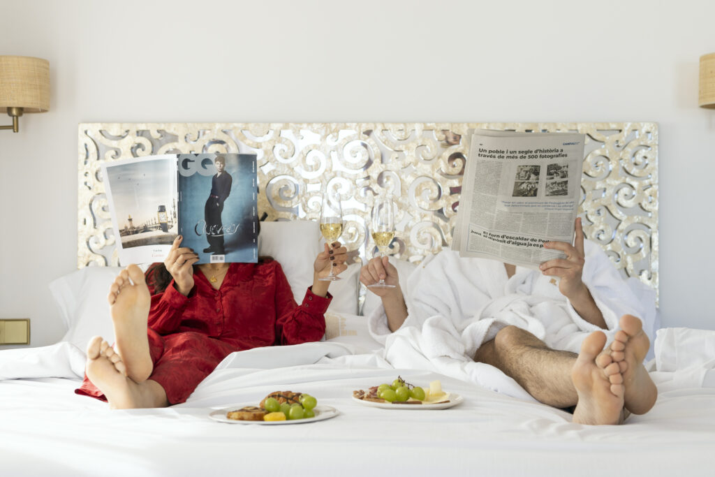Una pareja disfrutando una copa de champagne en la cama